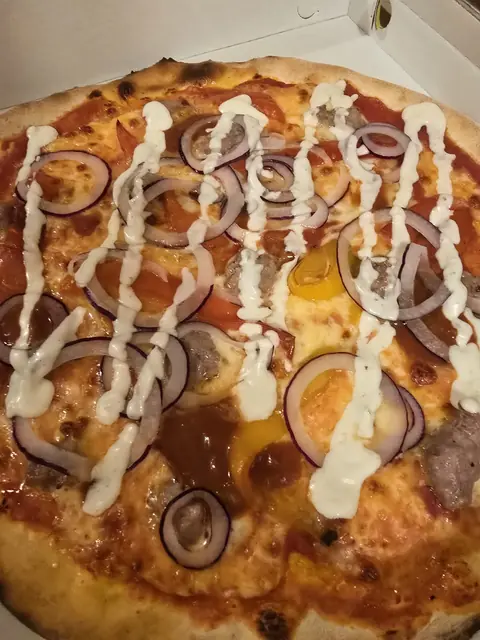 Pizza Messicana con salsiccia, anelli di cipolla, peperoni, panna acida e salsa piccante