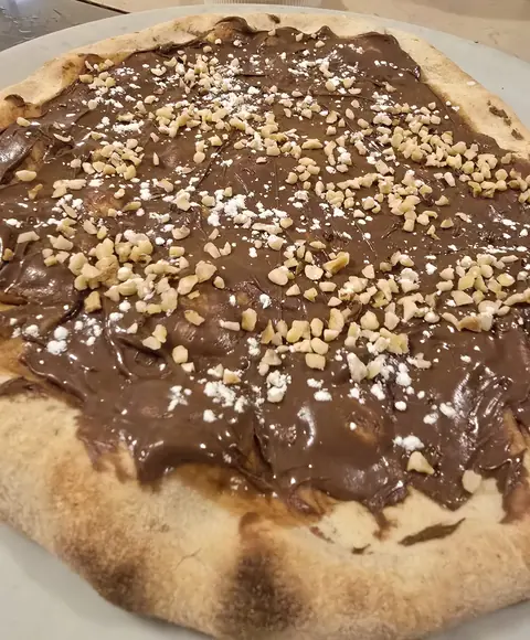 Pizza alla Nutella con granelli di nocciola e zucchero a velo